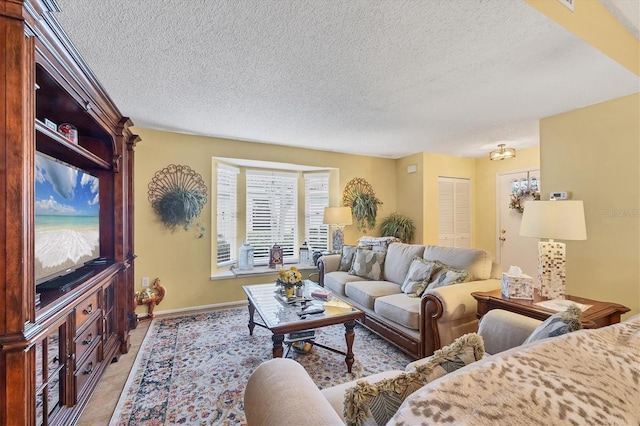 5614 Garden Lakes Dr, Bradenton, FL 34203 - living room with light tile patterned floors, a textured ceiling, and baseboards