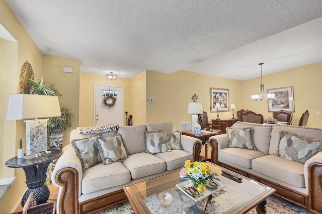5614 Garden Lakes Dr, Bradenton, FL 34203 - living area with a textured ceiling, visible vents, and a notable chandelier