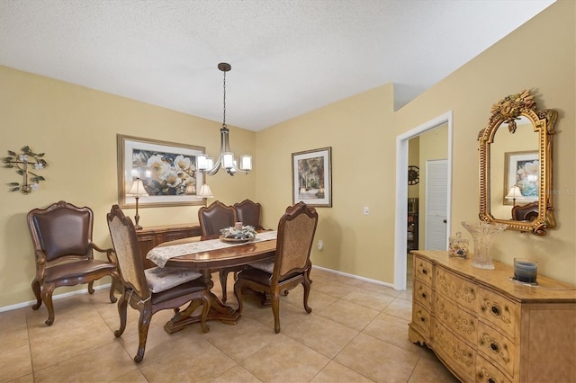 5614 Garden Lakes Dr, Bradenton, FL 34203 - dining space with a notable chandelier, a textured ceiling, baseboards, and light tile patterned floors