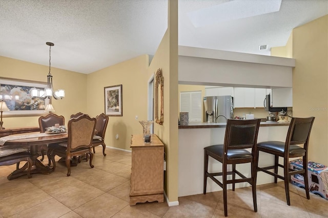 5614 Garden Lakes Dr, Bradenton, FL 34203 - dining space featuring a textured ceiling, light tile patterned floors, visible vents, and baseboards