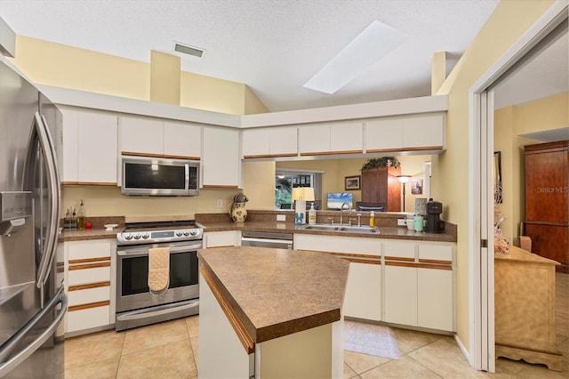 5614 Garden Lakes Dr, Bradenton, FL 34203 - kitchen with dark countertops, white cabinetry, and stainless steel appliances