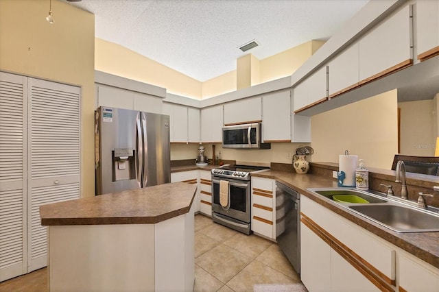5614 Garden Lakes Dr, Bradenton, FL 34203 - kitchen featuring dark countertops, light tile patterned floors, stainless steel appliances, and a sink
