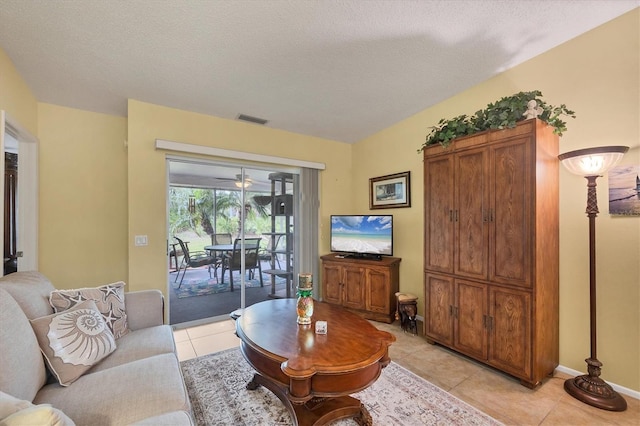 5614 Garden Lakes Dr, Bradenton, FL 34203 - living room featuring light tile patterned floors, a textured ceiling, visible vents, and baseboards
