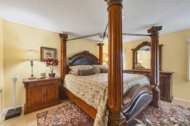 5614 Garden Lakes Dr, Bradenton, FL 34203 - bedroom featuring a textured ceiling, decorative columns, and baseboards