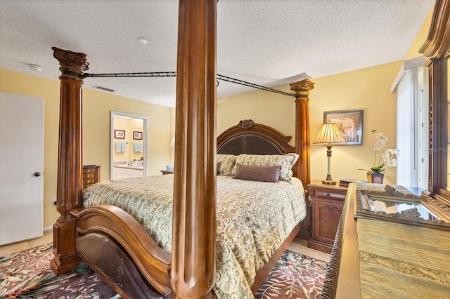 5614 Garden Lakes Dr, Bradenton, FL 34203 - bedroom with a textured ceiling, decorative columns, visible vents, and connected bathroom