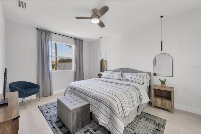 bedroom with a ceiling fan, baseboards, visible vents, and light wood-type flooring