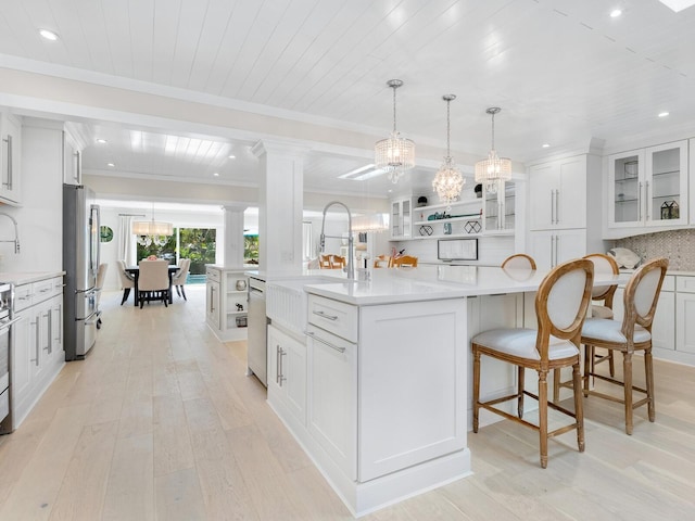 kitchen featuring a spacious island, white cabinets, light countertops, appliances with stainless steel finishes, and decorative backsplash