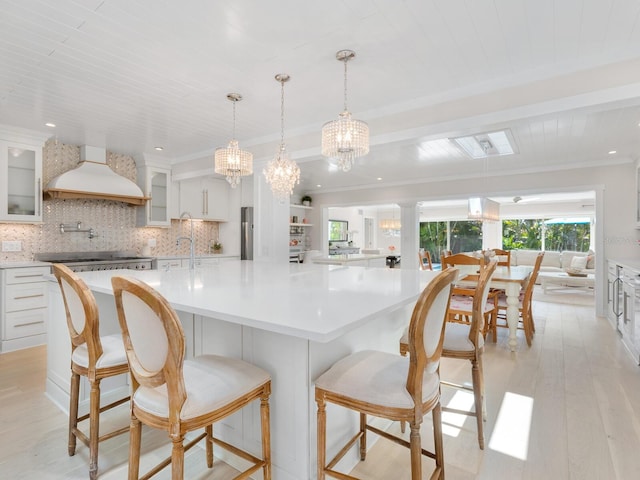 kitchen featuring tasteful backsplash, stainless steel appliances, white cabinets, and custom exhaust hood