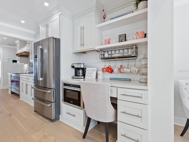 kitchen with light wood finished floors, white cabinets, appliances with stainless steel finishes, premium range hood, and open shelves