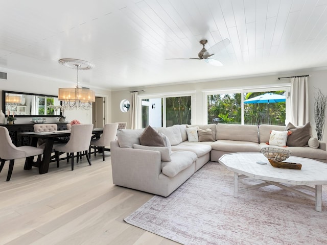 living room featuring light wood-style floors, plenty of natural light, visible vents, and ornamental molding