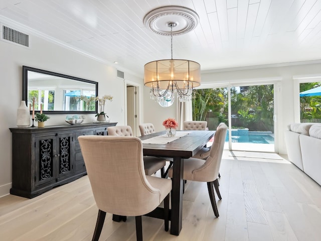 dining space featuring a chandelier, visible vents, and light wood finished floors