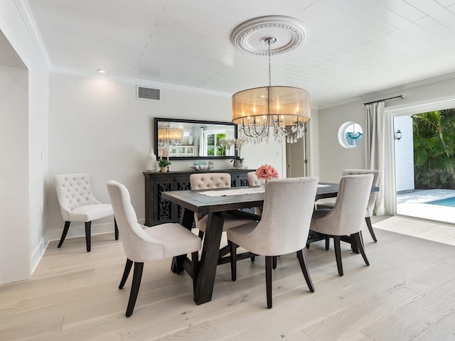 dining area featuring baseboards, visible vents, light wood-style flooring, ornamental molding, and a notable chandelier