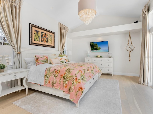 bedroom featuring lofted ceiling, light wood-type flooring, and a notable chandelier