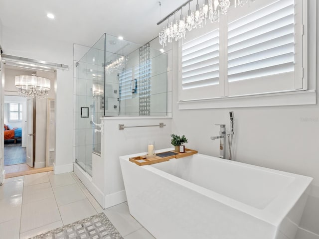 bathroom with baseboards, a freestanding bath, tile patterned floors, a stall shower, and ensuite bath