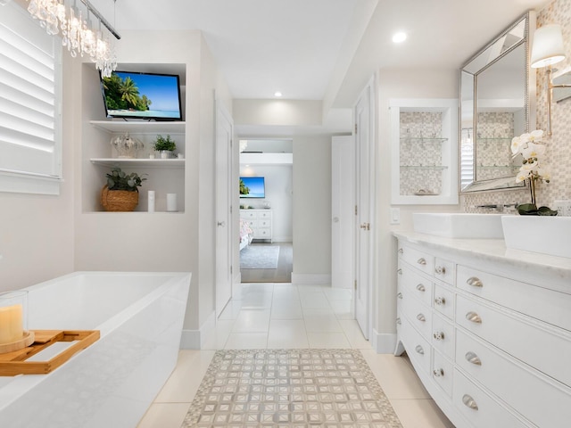 bathroom featuring tasteful backsplash, recessed lighting, vanity, tile patterned flooring, and a freestanding tub