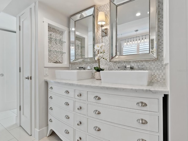 full bath featuring double vanity, decorative backsplash, and a sink