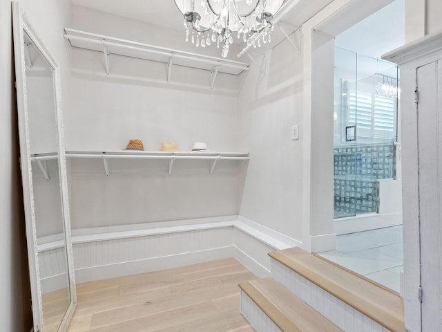 walk in closet featuring a chandelier and wood finished floors