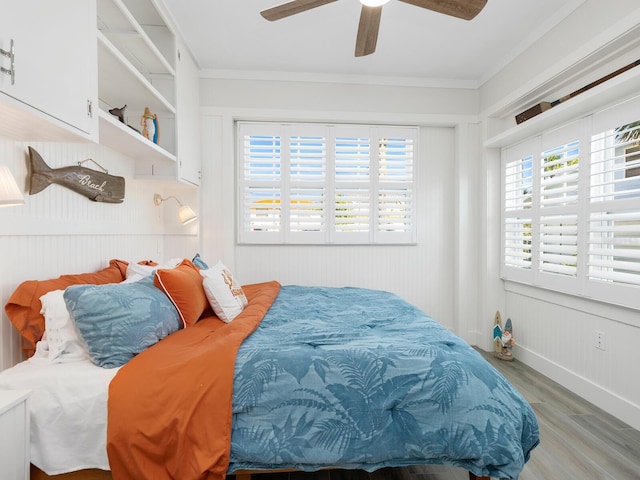 bedroom featuring light wood-style floors, multiple windows, and crown molding