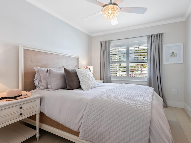 bedroom with light wood-style floors, crown molding, baseboards, and ceiling fan