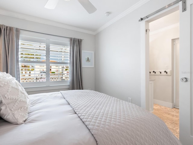 bedroom featuring ornamental molding, ceiling fan, baseboards, and a barn door