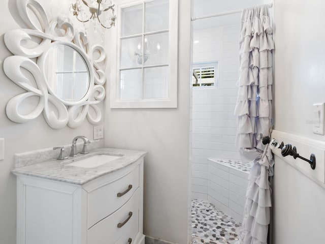 full bathroom with tiled shower and vanity