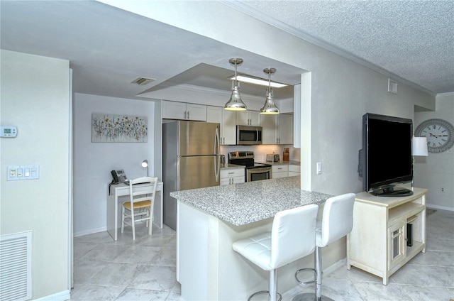 kitchen with a textured ceiling, visible vents, stainless steel appliances, and crown molding