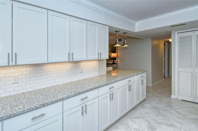 kitchen with white cabinetry, visible vents, backsplash, light stone countertops, and crown molding