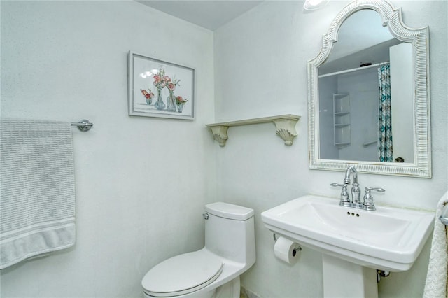 full bath featuring toilet, curtained shower, and a sink