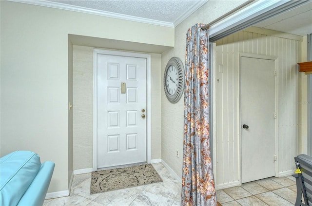 foyer entrance featuring a textured ceiling, baseboards, and crown molding