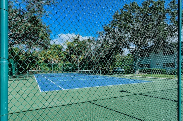 view of tennis court featuring fence