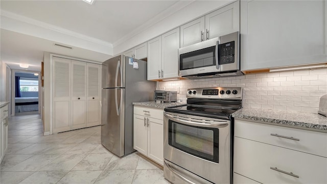 1711 Southwood St Unit 1711, Sarasota, FL 34231 - kitchen featuring ornamental molding, stainless steel appliances, tasteful backsplash, and visible vents
