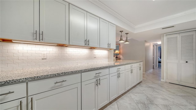 1711 Southwood St Unit 1711, Sarasota, FL 34231 - kitchen with white cabinets, light stone counters, marble finish floor, backsplash, and visible vents