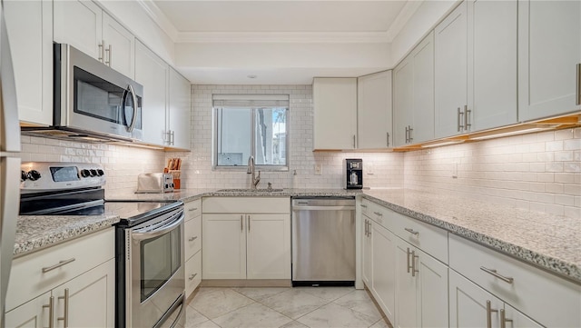 1711 Southwood St Unit 1711, Sarasota, FL 34231 - kitchen with appliances with stainless steel finishes, ornamental molding, a sink, and tasteful backsplash
