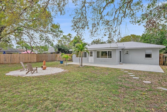 rear view of house with a fenced backyard, a patio, and stucco siding