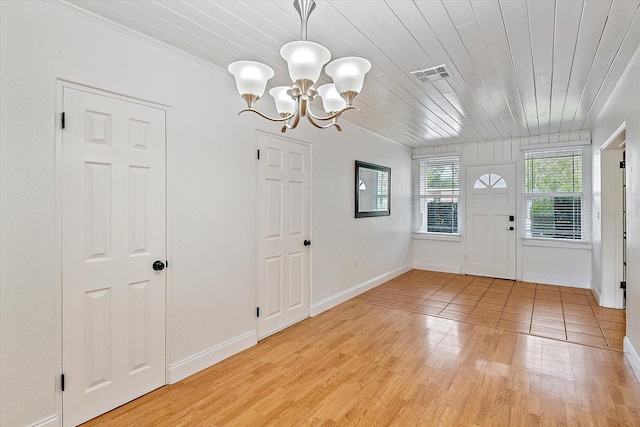 entrance foyer featuring light wood-style floors, wood ceiling, visible vents, and an inviting chandelier