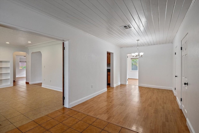 empty room featuring visible vents, arched walkways, wood ceiling, crown molding, and a notable chandelier