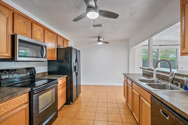 kitchen featuring visible vents, decorative backsplash, black appliances, a sink, and light tile patterned flooring