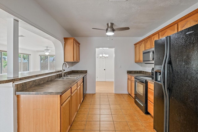 kitchen with light tile patterned floors, dark countertops, a sink, a textured ceiling, and black appliances