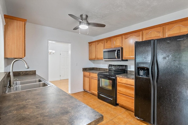 kitchen with dark countertops, a ceiling fan, light tile patterned flooring, a sink, and black appliances