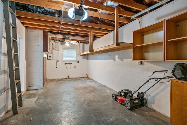 basement featuring electric panel and concrete block wall