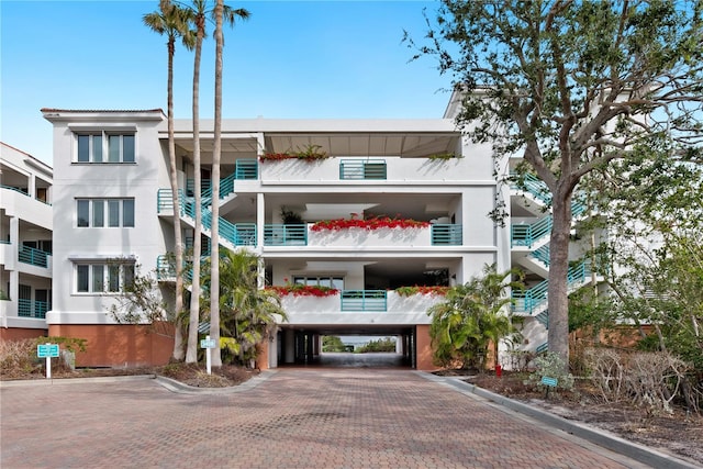 view of property with a carport and decorative driveway