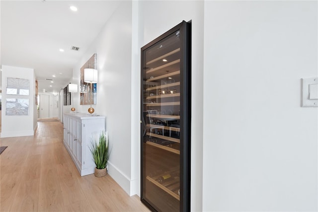 corridor featuring beverage cooler, recessed lighting, baseboards, and light wood-style floors