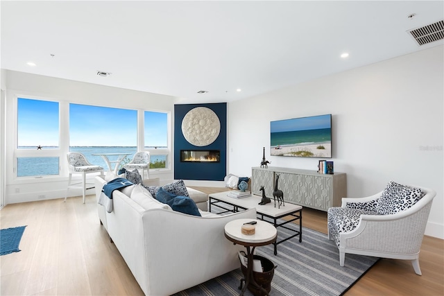 living room featuring recessed lighting, visible vents, wood finished floors, and a fireplace