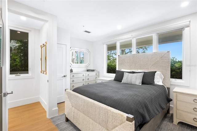 bedroom with light wood-style flooring, baseboards, and visible vents