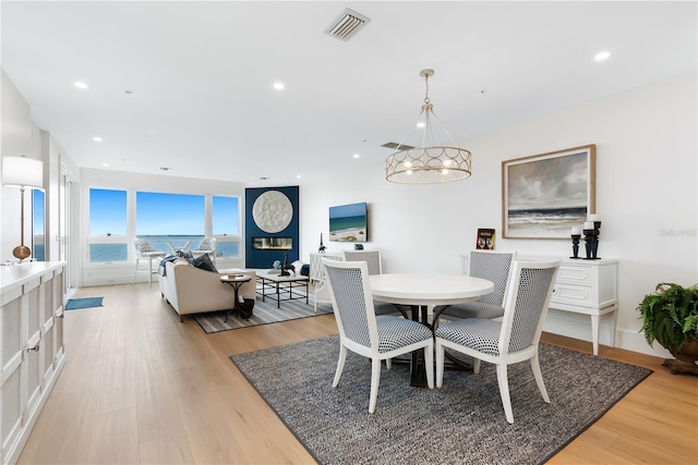 dining space with visible vents, recessed lighting, light wood-type flooring, and an inviting chandelier