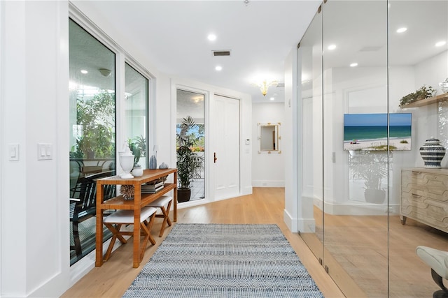 corridor with recessed lighting, light wood-style floors, visible vents, and a wealth of natural light