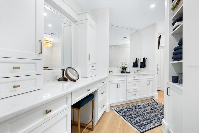 bathroom with visible vents, wood finished floors, and vanity