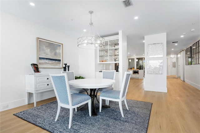 dining room with light wood finished floors, visible vents, recessed lighting, and a chandelier