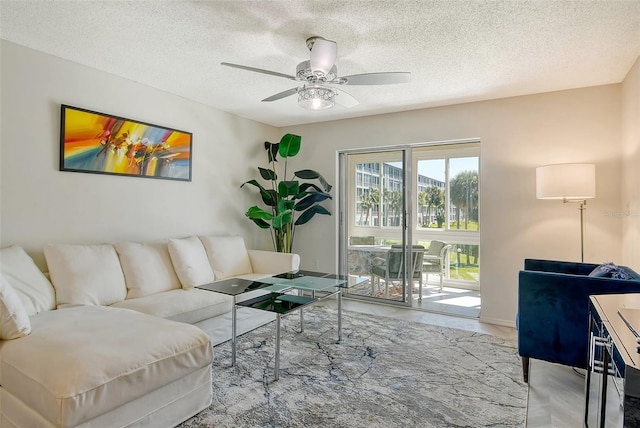 living area featuring ceiling fan and a textured ceiling