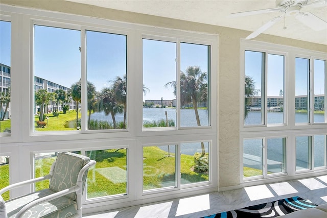 sunroom / solarium featuring a water view and a ceiling fan